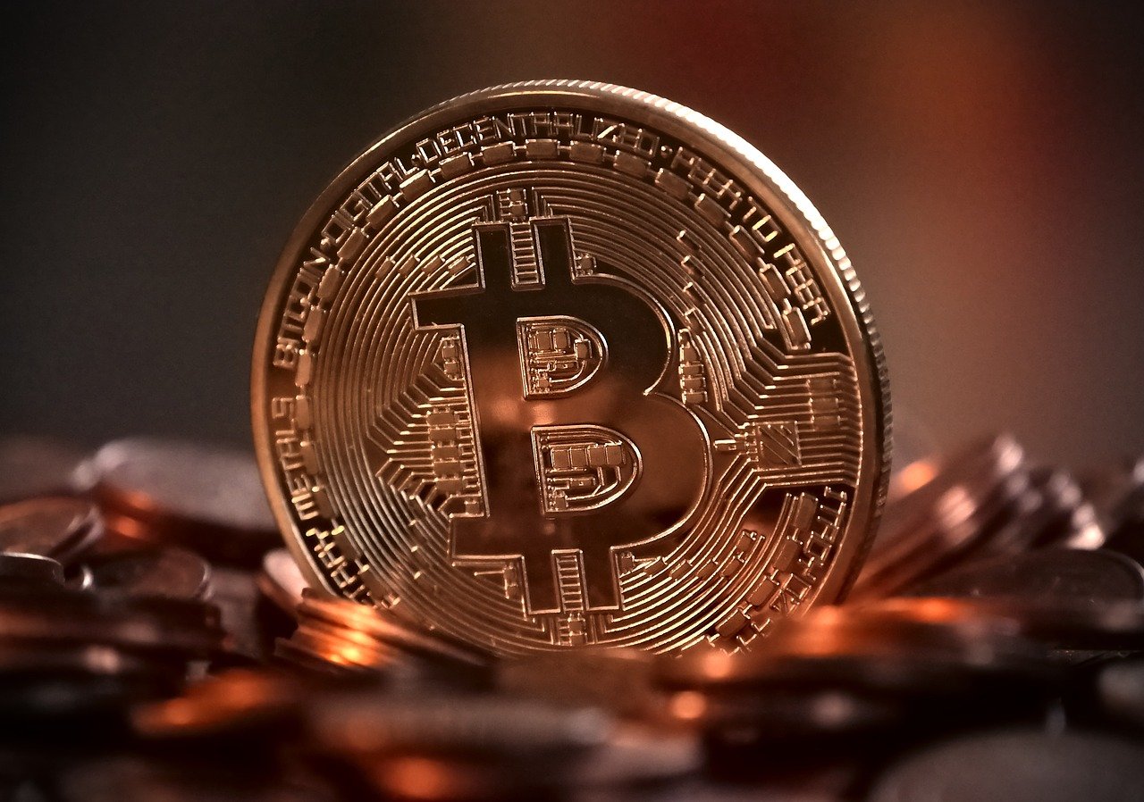 A physical coin imprinted with a Bitcoin logo.