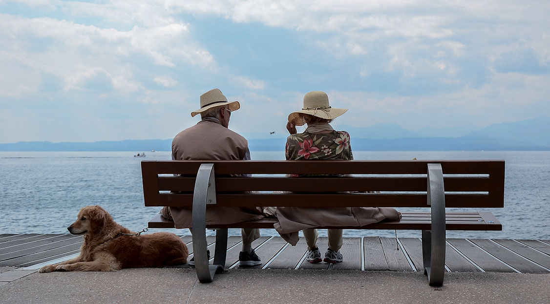 Two people on a bench by the sea