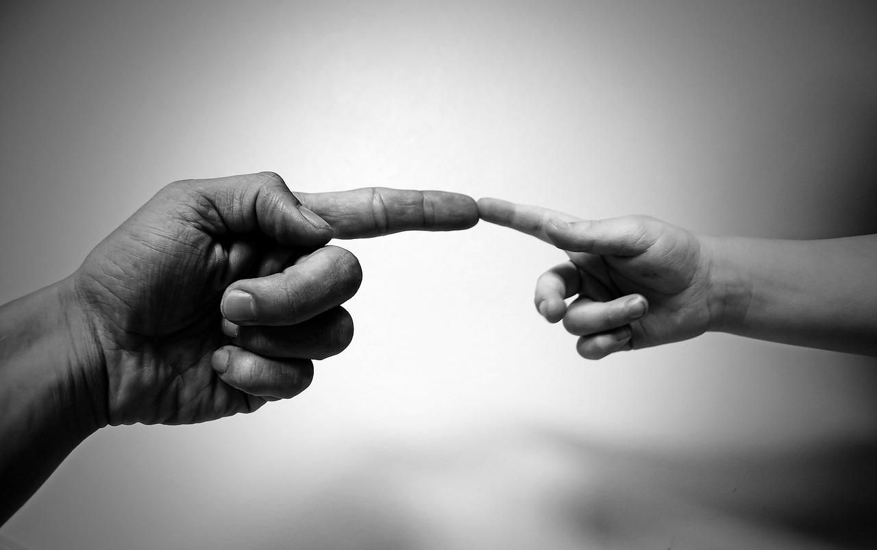 根据米开朗基罗的画作，成人的手指触摸孩子的手指