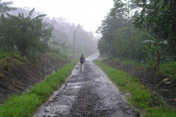 在雨中沿着土路走的人