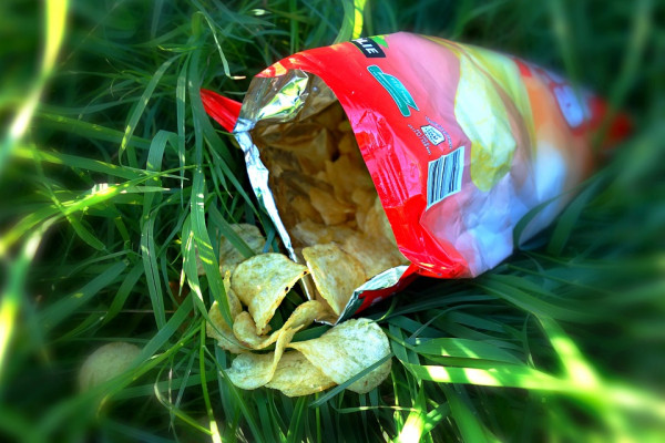 草地上的一包打开的薯片