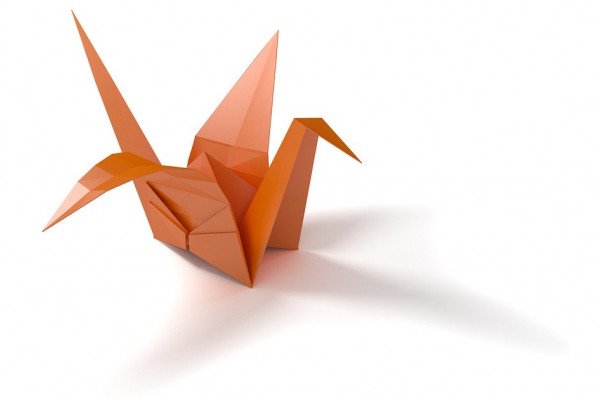 A traditional Japanese origami crane folded with orange paper