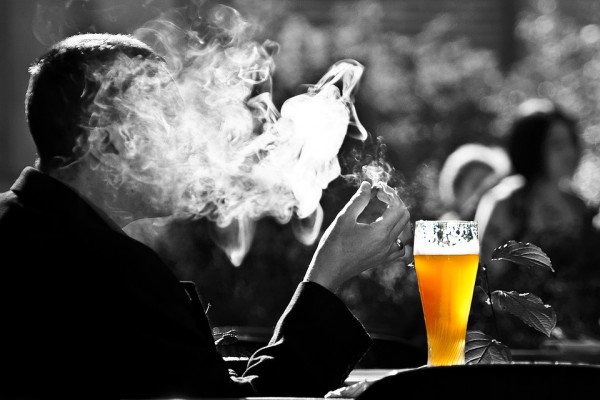 一个吸烟者享受着一品脱啤酒
