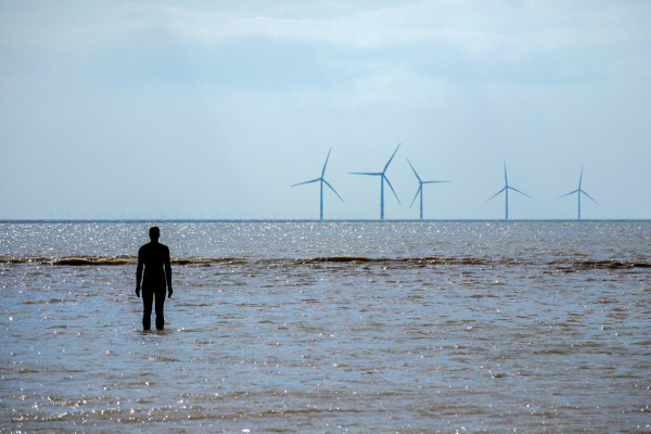 安东尼·戈姆利在克罗斯比海滩的“另一个地方”展览，背景是波波河岸风电场