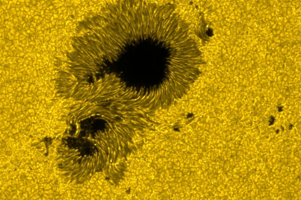 太阳表面的颗粒状结构和太阳黑子(大小约2万公里)。可见光。由日野的太阳光学望远镜(SOT)拍摄。
