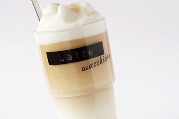 This photograph shows a glass of latte macchiato, which is a hot beverage made from steamed milk and espresso.