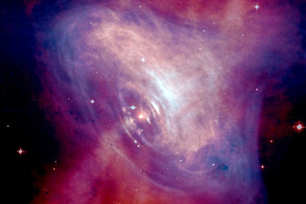 蟹状星云的合成图像，显示了x射线(蓝色)和光学图像(红色)的叠加。x射线图像的尺寸较小，因为高能x射线发射的电子比低能x射线发射的电子更快地辐射掉它们的能量。