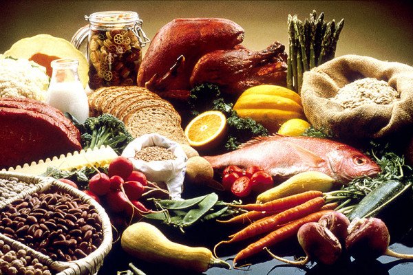 这张图片展示了桌子上的健康食品。食物包括豆类、谷物、菜粉、莴苣、面食、面包、橙子、火鸡、鲑鱼、胡萝卜、芜菁、西葫芦、雪豆、菜豆、萝卜、芦笋、夏南瓜、瘦牛肉……