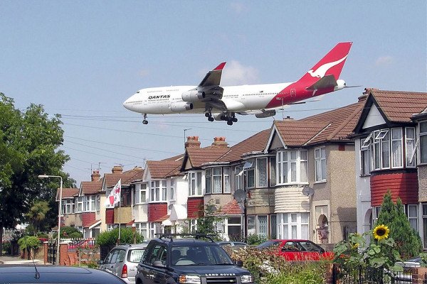 在英国伦敦希思罗机场，一架澳航的波音747-400正在接近27L跑道。这些房子位于机场东南角的默特尔大道。