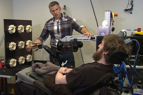 匹兹堡大学的罗伯特·冈特博士和十年前脊椎受伤的内森·科普兰，现在已经接受了大脑植入，使他能够用这只手体验感觉。