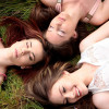 一群女friends laying together in a field