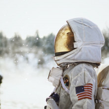 一位宇航员在雪地里侧影，仰望天空