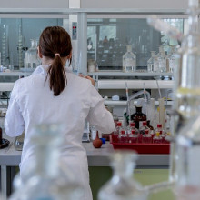 在实验室里，一个女人背对着相机，使用科学设备