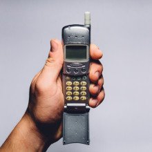一只手拿着一个旧手机的图像