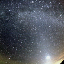 猎户座流星撞击银河系下方和金星右侧的天空。黄道光也可以在图像中看到。由于镜头的边缘扭曲，流星的轨迹看起来有点弯曲。