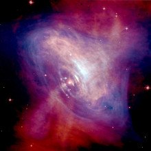 蟹状星云的合成图像，显示了x射线(蓝色)和光学图像(红色)的叠加。x射线图像的尺寸较小，因为高能x射线发射的电子比低能x射线发射的电子更快地辐射掉它们的能量。