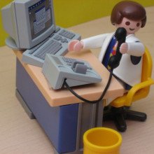 A Playmobil man sitting at a desk